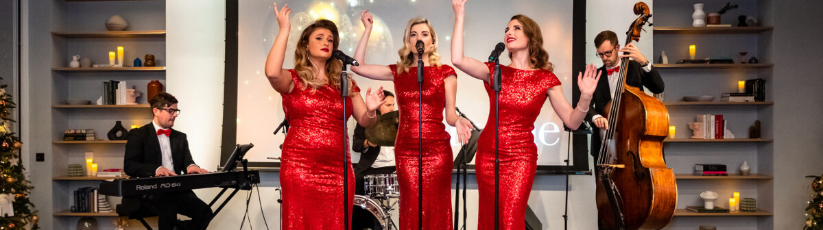 Three women singing at a Christmas party hosted at a Convene
