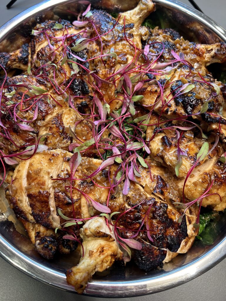 Yuzu-glazed chicken with purple garnish by Convene chefs. 