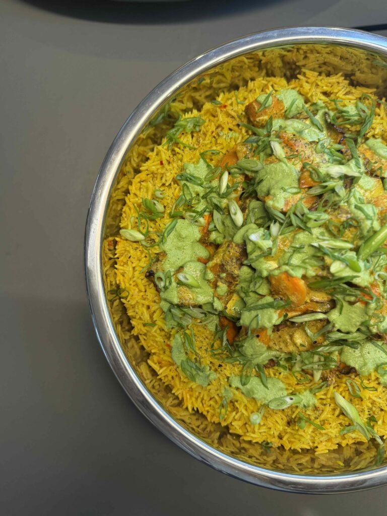 Sunchoke and carrot biryani with herbs and a cilantro-mint chutney in metal platter by Convene One Boston Place chef. 