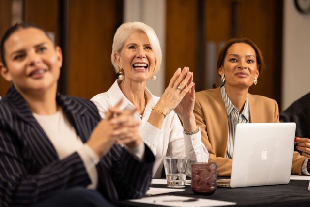 etc.venues for Corporate Conferences shows a female audience clapping for a presentation